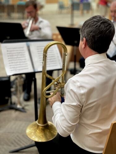 A man plays the trombone during a musical performance.